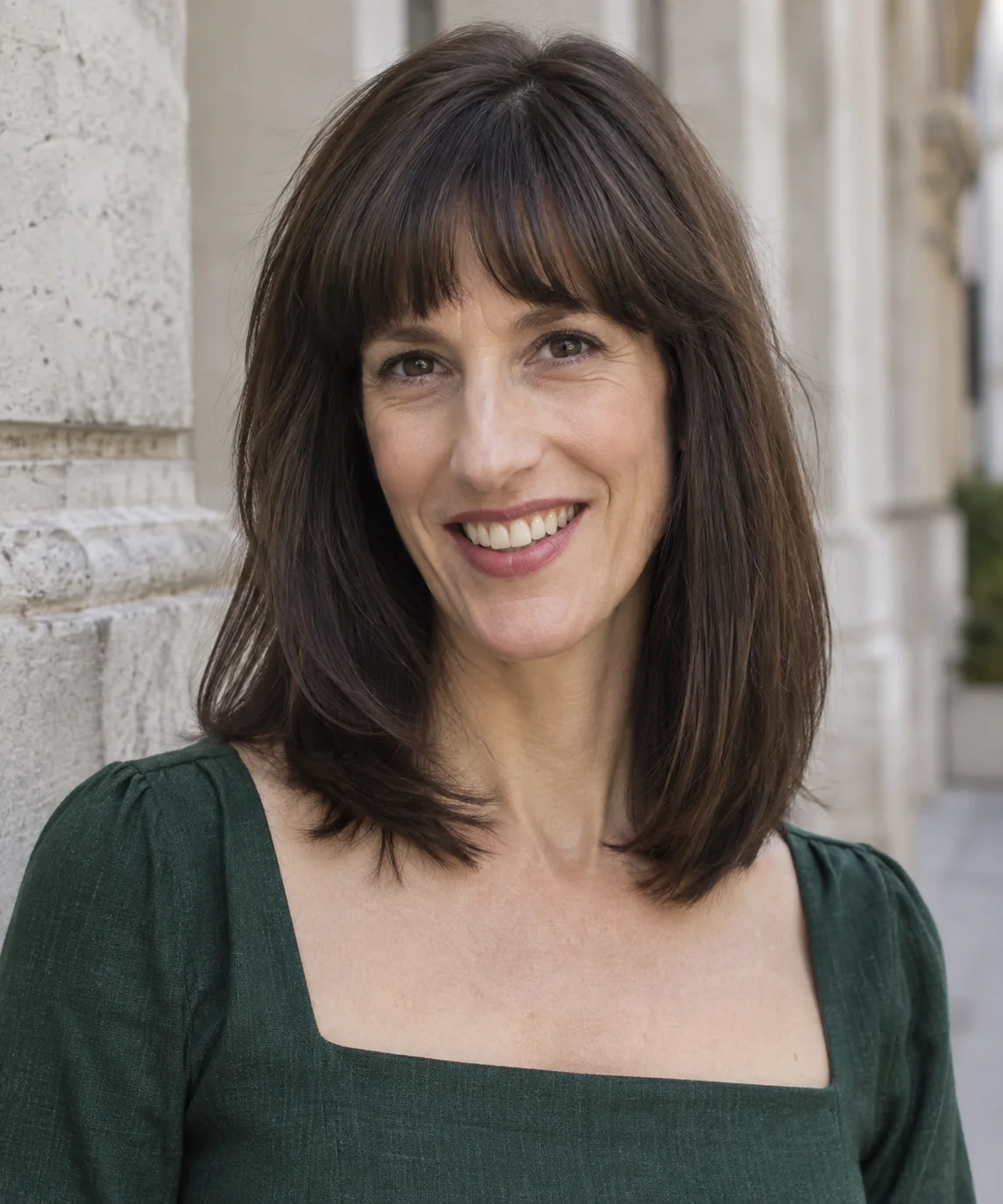 Woman with shoulder-length hair and softly arched bangs